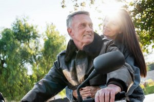 Senior couple taking a ride on a motorcycle.